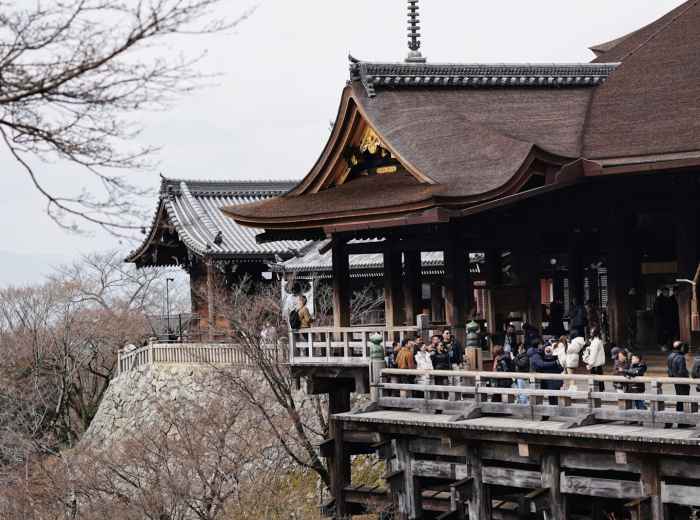 Wooden temple platform extending over hillside with panoramic city views Photo by fan yang on Unsplash
