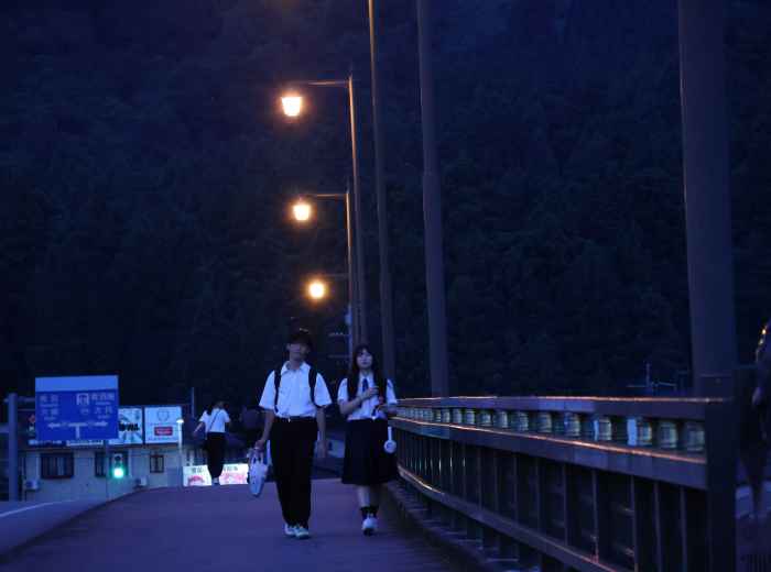 A traveler and host crossing a quiet bridge in Kyoto's early morning light Photo by Yanhao Fang on Unsplash