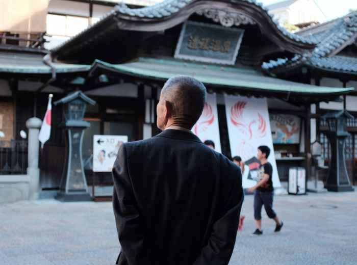Traveler pausing to admire traditional architecture with a local host nearby Photo by Mak on Unsplash