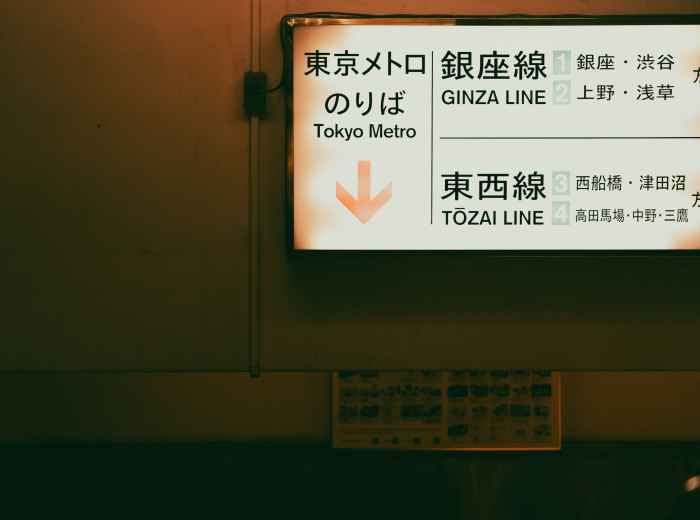 Multilingual signage at a major Osaka train station with tourists consulting maps Photo by ayumi kubo on Unsplash