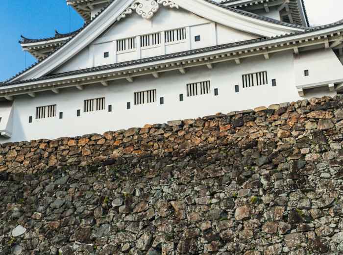 Magnificent Himeji Castle in its full white glory against a blue sky, with traditional landscaping in the foreground Photo by HYEWON HWANG on Unsplash