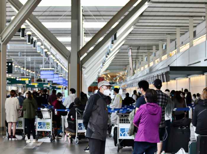 Welcome scene at Osaka train station or airport with travelers arriving, luggage in hand, looking excited about their upcoming adventure Photo by Charles Gao on Unsplash