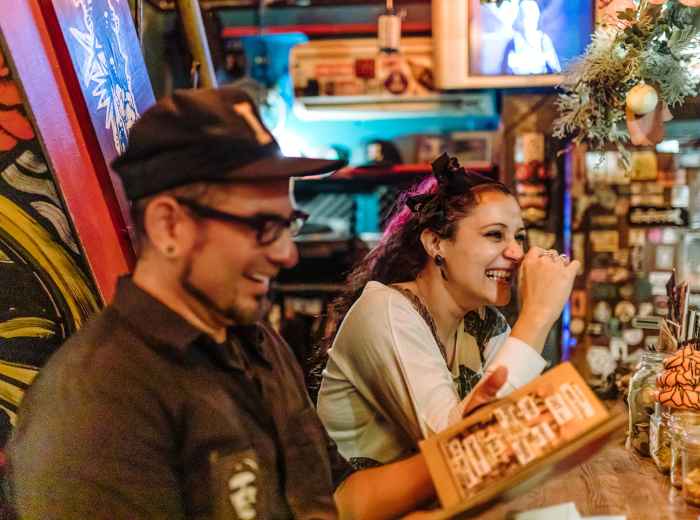 Traveler and host laughing in café