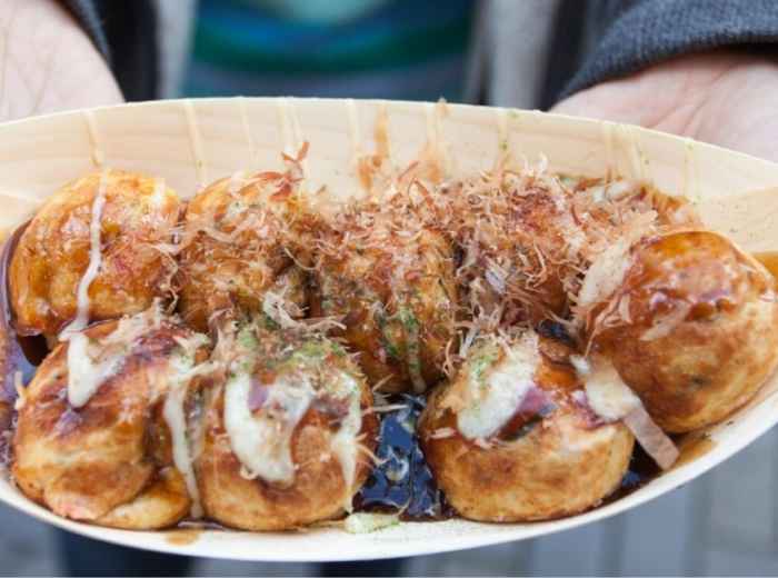 Close-up of perfectly round takoyaki with bonito flakes dancing on top.