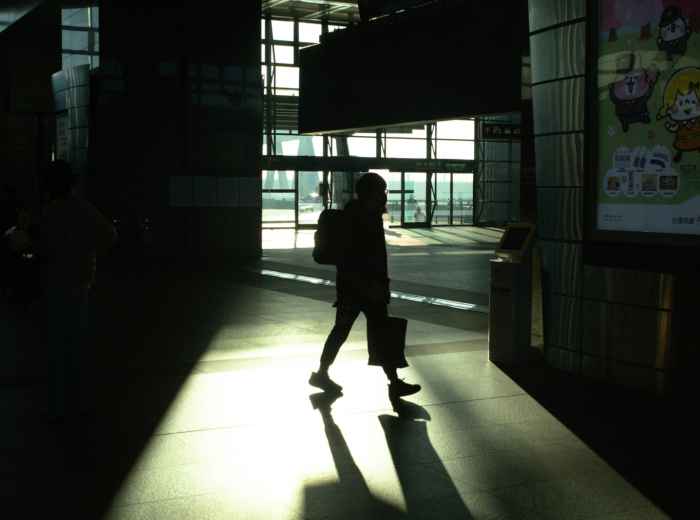 Early morning commuters at Osaka Station with the sunrise filtering through glass Photo by hayato togashi on Unsplash