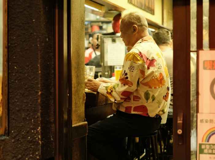 Elderly couple enjoying skewers at a corner eatery.  Photo by Perry Merrity II on Unsplash