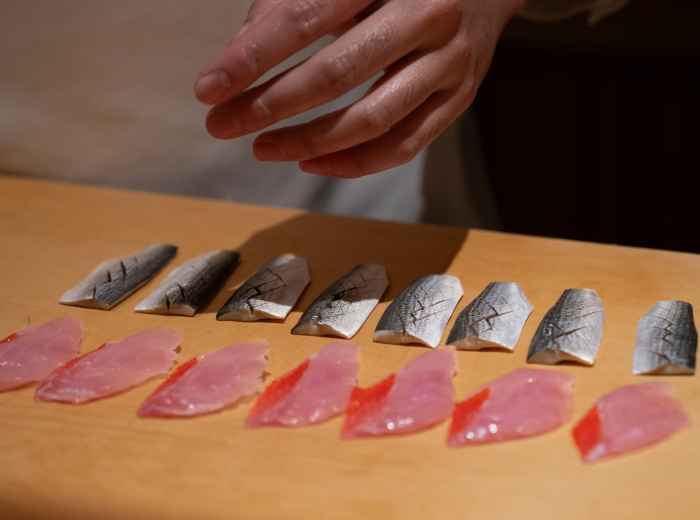 Intimate sushi counter at a local restaurant with chef preparing fresh fish Photo by Harrison Chang on Unsplash