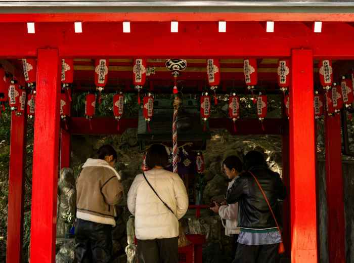 A guide explaining temple etiquette to guests at a quiet traditional temple.Photo by Kouji Tsuru on Unsplash