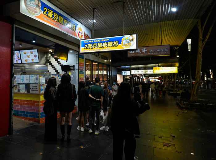 Food stalls near a busy train station with commuters and tourists. Photo by 1Click on Unsplash