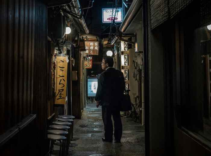  Guest stepping into a narrow, lantern-lit alleyway in Osaka's vintage district Photo by Guillaume Gouin on Unsplash