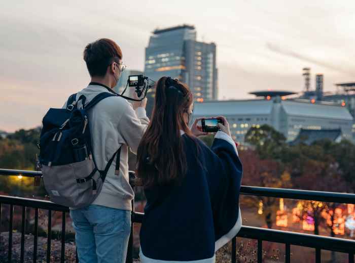 Tourist taking photo at iconic Osaka landmark with guide assisting Photo by Rory McKeever on Unsplash