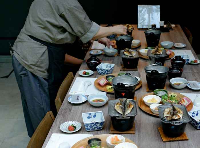 Group of people sharing various dishes at a traditional low table in Japanese style Photo by Kristian Angelo on Unsplash
