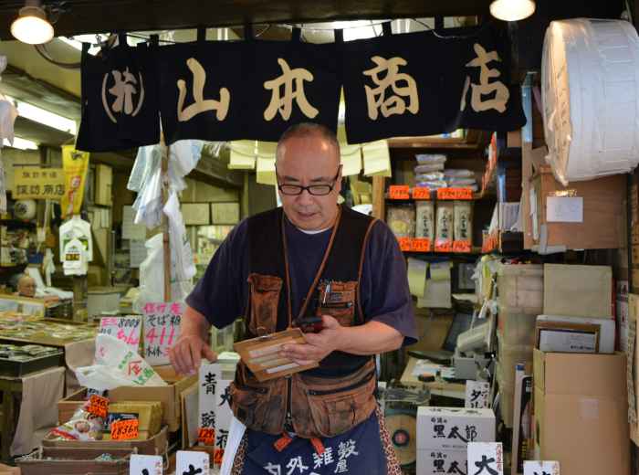 Tourist showing a translation card to a food vendor who is smiling and nodding in understanding Photo by Beth Macdonald on Unsplash