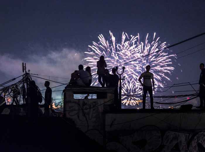  Crowds gathering on rooftops to watch distant fireworks. Photo by Aleksandr Popov on Unsplash
