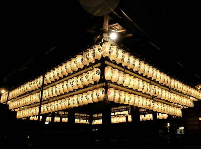 Traditional temple buildings illuminated at night with paper lanterns creating atmospheric lighting Photo by Adalee Penguin on Unsplash