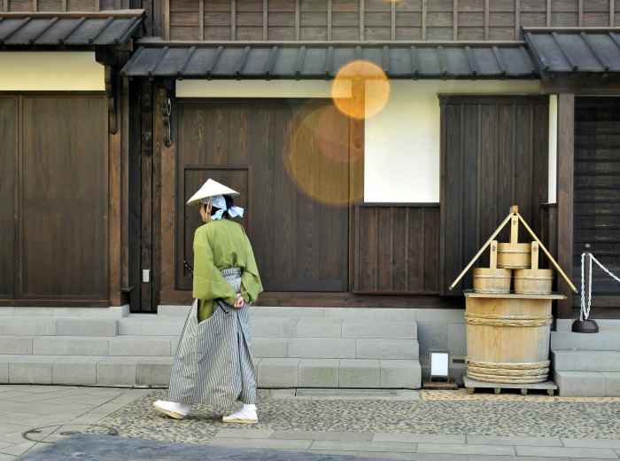 Local resident walking past a small neighborhood shrine Photo by Boudewijn Huysmans on Unsplash