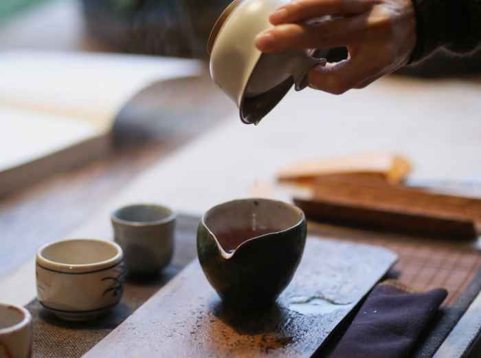 Hands performing traditional tea ceremony movements. Photo by Huang 211 on Unsplash