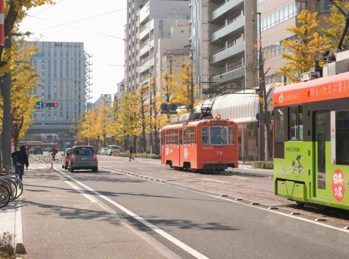 Traditional Kyoto city bus with autumn street scene reflected Photo by Mak on Unsplash
