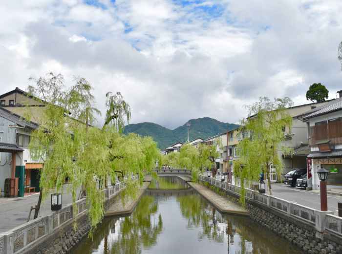 A traditional wooden bridge over Shirakawa canal with weeping willows Photo by Sunao Noguchi on Unsplash
