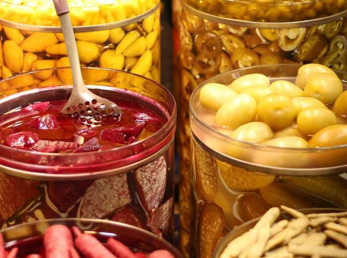 Customers sampling various pickled vegetables and traditional preserved foods at market stalls Photo by Nuriye Çayhan on pexels