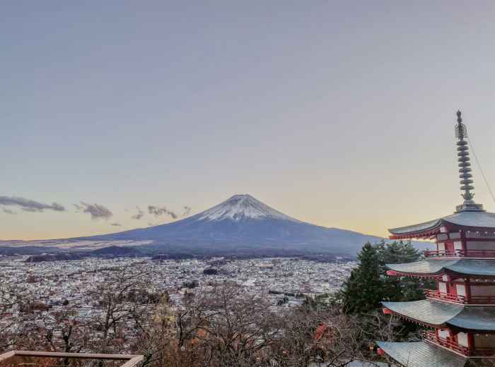 Snow-covered temple roofs in winter with Mount Fuji visible in the distance Photo by Maria Clarissa Badiola on Unsplash