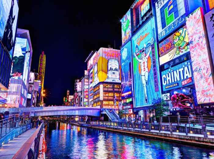 A vibrant, neon-lit street scene from Namba, capturing the energy of Osaka at night.
