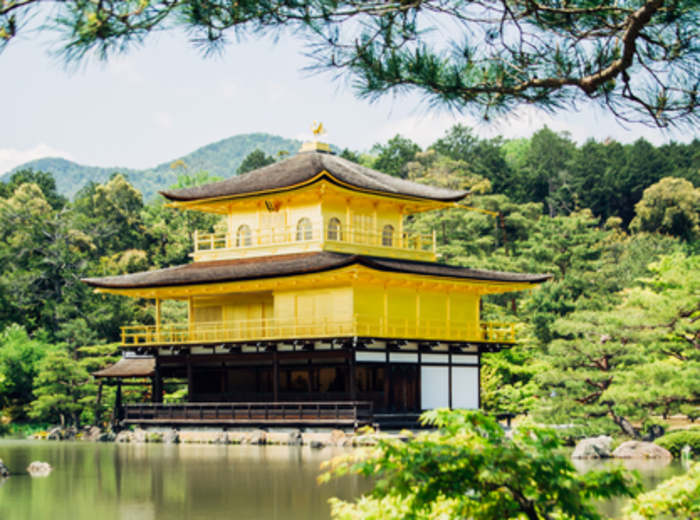 The Golden Pavilion in Kyoto mirrored in a serene pond framed by seasonal gardens