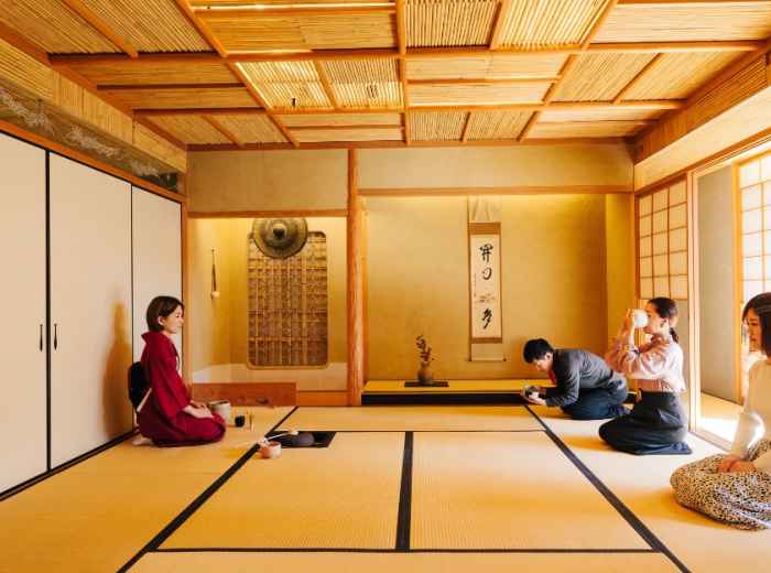 Matcha bowls, whisks, and utensils arranged neatly in a quiet tatami room