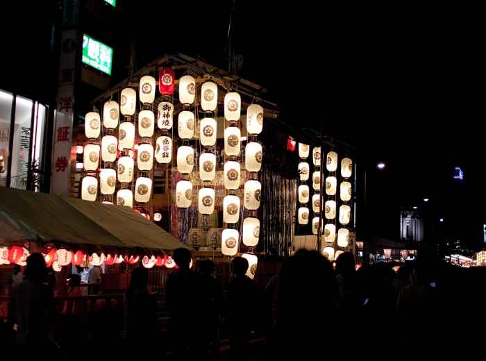 Gion Festival floats illuminated at night. Photo by nekonomania via Wikicommons