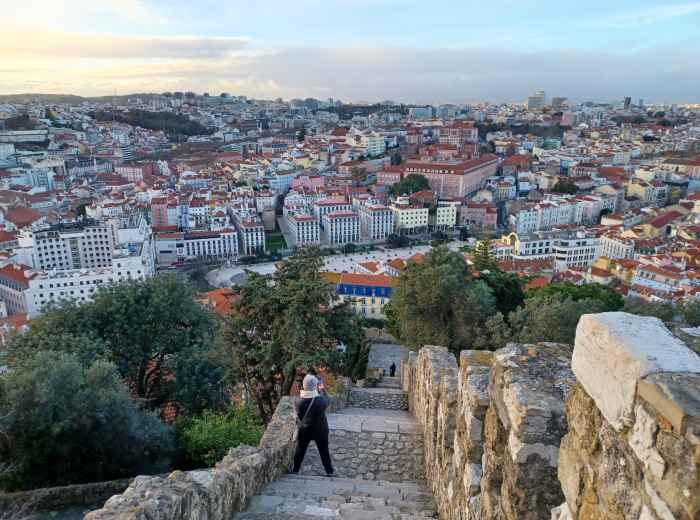 Stone walls of Castelo de São Jorge overlooking Lisbon’s rooftops at dusk