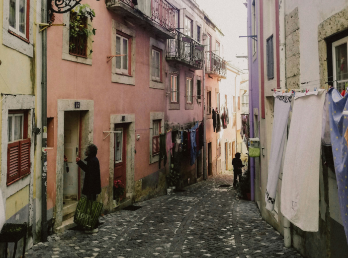 Narrow alley with laundry hanging between buildings in Alfama