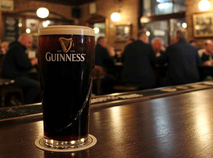 A proper pint of Guinness poured in a traditional Dublin pub setting