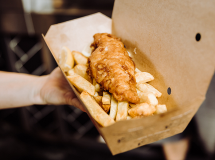 Golden fish and chips with mushy peas on newspaper