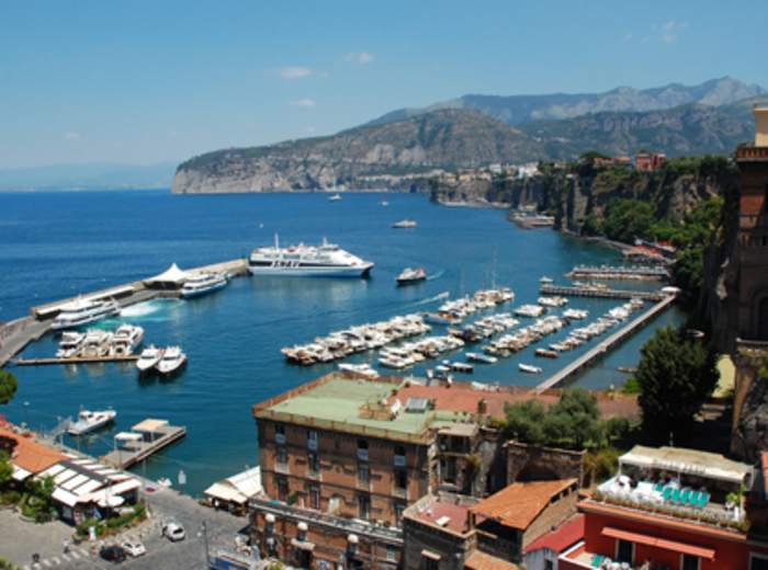 Busy harbor with boats and waterfront hillside buildings