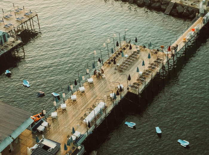 Small harbor with fishing boats and waterfront cafes in the sun