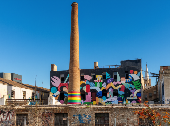 Brick factory wall with layered street art