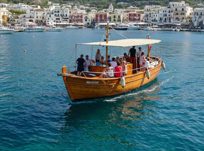 Traditional fishing boat departing Marina Grande with crystal clear waters and passengers