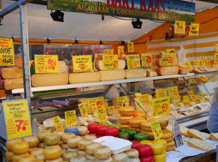 Piazza Ghiaia morning market with locals choosing produce and cheeses 
