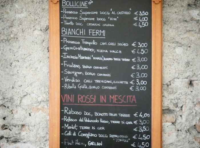Parma trattoria with handwritten menu and a glass of Lambrusco 