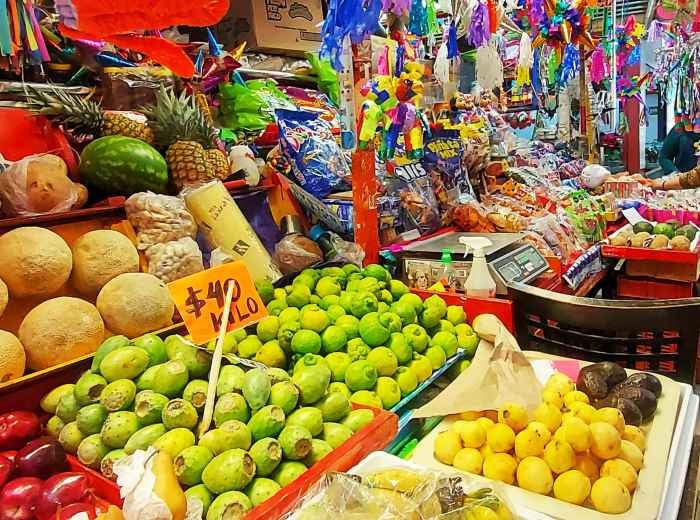 Fruit stalls with handwritten signs and shoppers