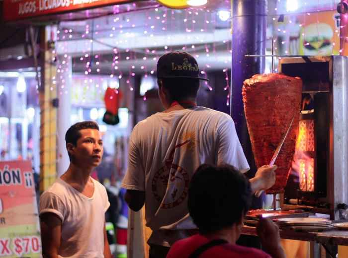 Row of suadero taco stands in Narvarte with Tacos al Pastor preparation