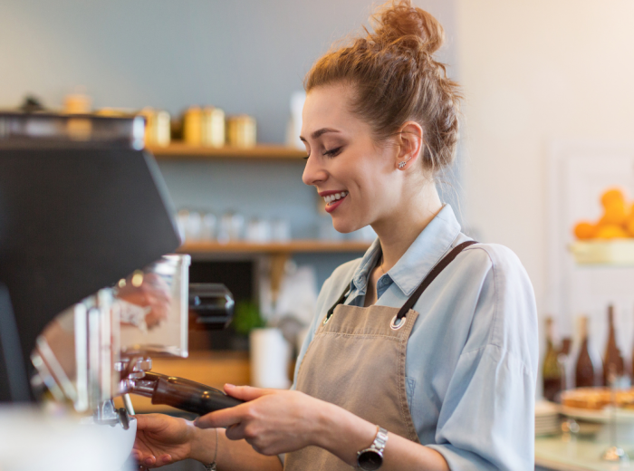 Friendly barista making cappuccino at a Milan café counter