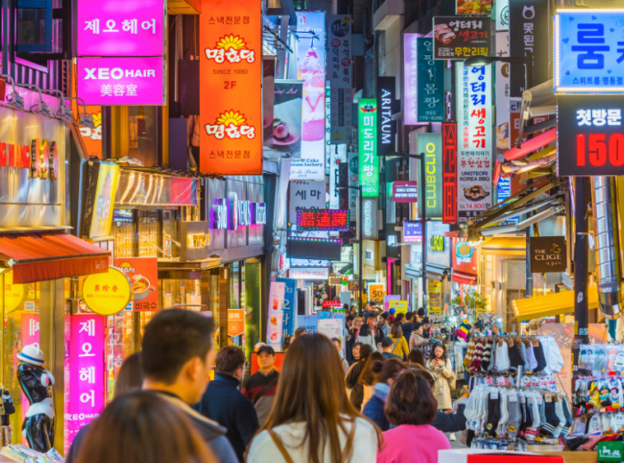 A busy neon-lit shopping street in Myeongdong City