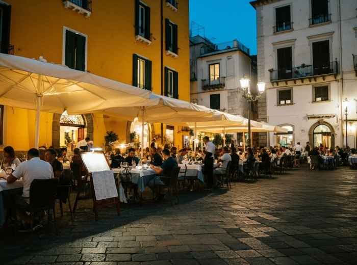 Busy Sorrento trattoria with locals dining, menus on tables, and evening coastal light