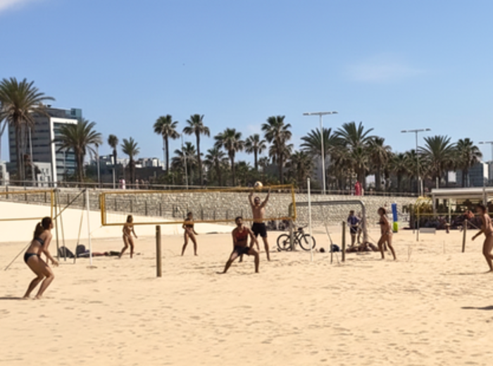 Local volleyball game at Bogatell beach on a sunny day