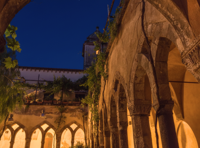 Stone arches of San Francesco cloister lit at night