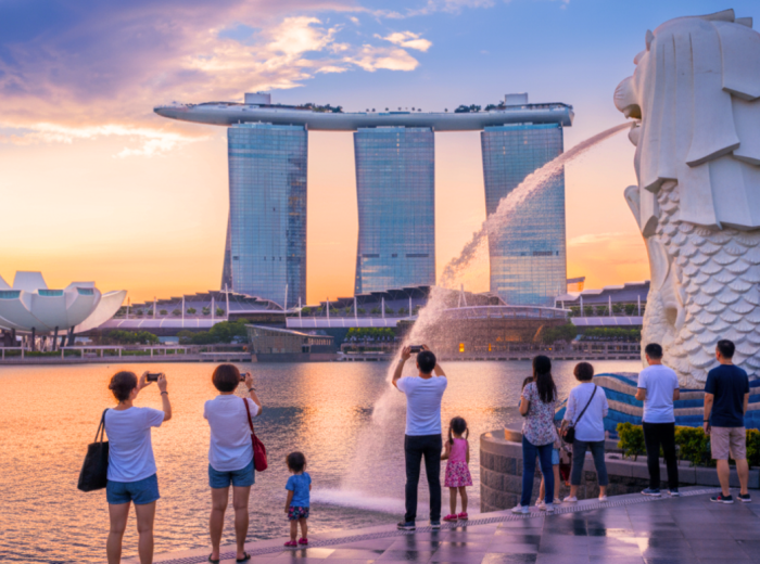 Merlion statue facing Marina Bay with Marina Bay Sands in the distance at dusk