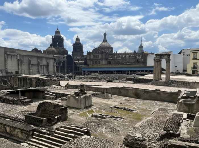 Templo Mayor stones with cathedral tower behind