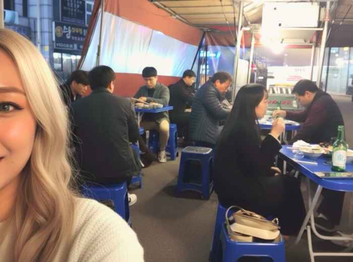 Late evening pojangmacha tent with locals sharing soju and street food