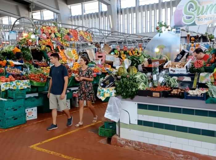 Vibrant stalls at Mercado de Alvalade with locals shopping for fresh produce